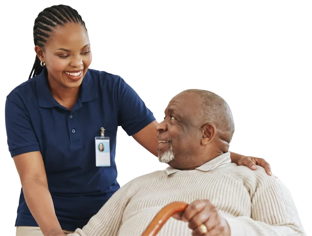 Friendly female caregiver with an ID badge smiling at an elderly man holding a cane.